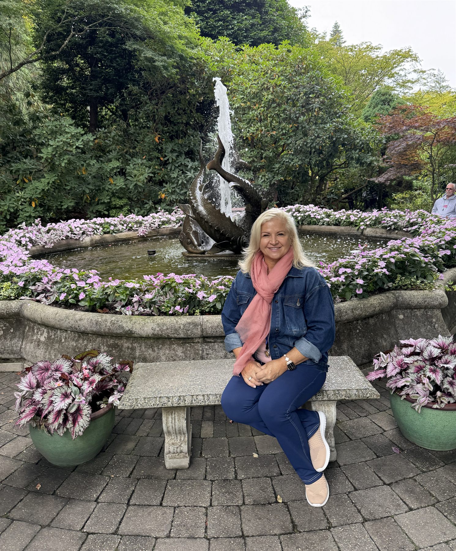 Lorena Ricci seated in a garden beside a fountain