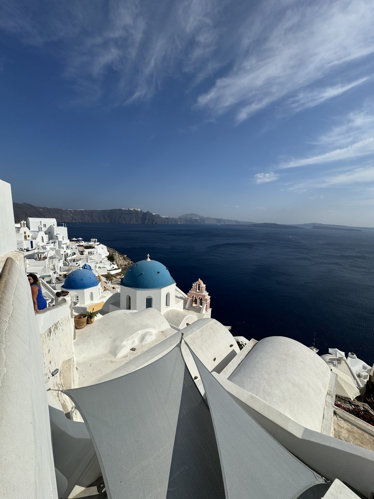 White hillside buildings and blue domes overlooking the sea in Greece
